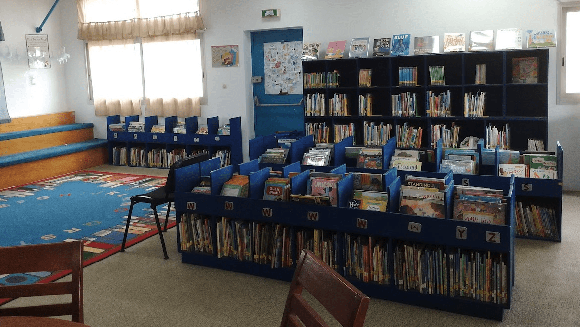 Picture of library with shelves and books in the background. 